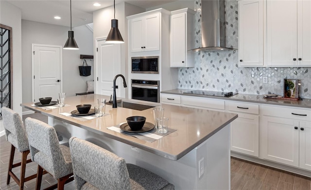 4409 Lions Gate Ave, Clermont, FL 34711 - kitchen with wall chimney range hood, appliances with stainless steel finishes, wood finished floors, decorative backsplash, and recessed lighting