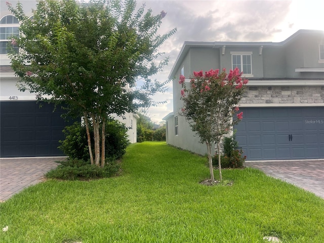 4409 Lions Gate Ave, Clermont, FL 34711 - view of property exterior featuring decorative driveway, stucco siding, and a lawn
