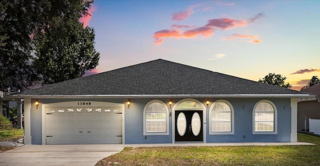 13848 Vista Del Lago Blvd, Clermont, FL 34711 - ranch-style house with driveway, stucco siding, a shingled roof, an attached garage, and a lawn
