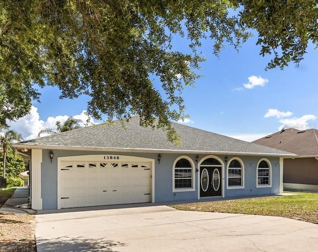 13848 Vista Del Lago Blvd, Clermont, FL 34711 - ranch-style house with a garage, driveway, stucco siding, and roof with shingles