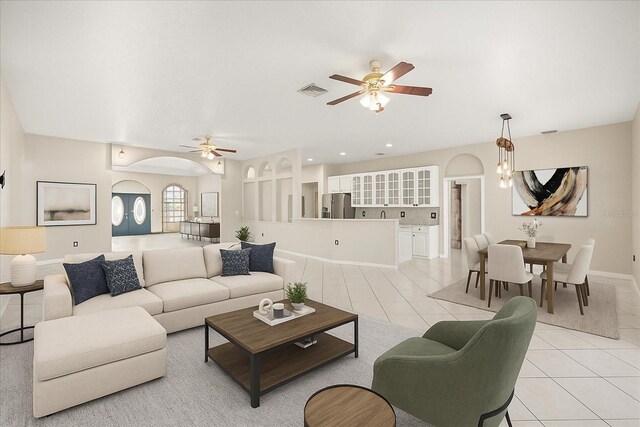 13848 Vista Del Lago Blvd, Clermont, FL 34711 - living room featuring light tile patterned floors, a ceiling fan, and arched walkways