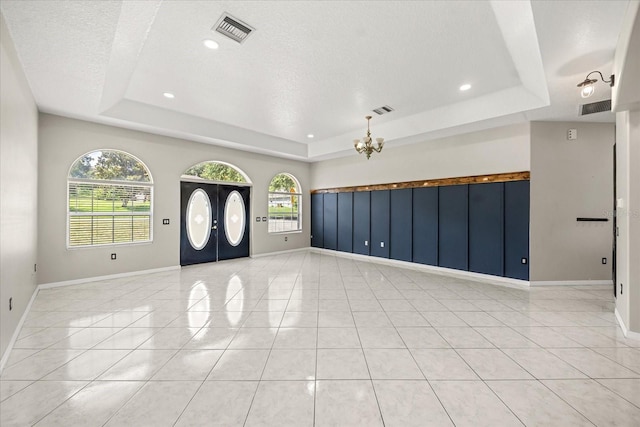 13848 Vista Del Lago Blvd, Clermont, FL 34711 - foyer entrance with a tray ceiling, recessed lighting, a textured ceiling, light tile patterned flooring, and a chandelier
