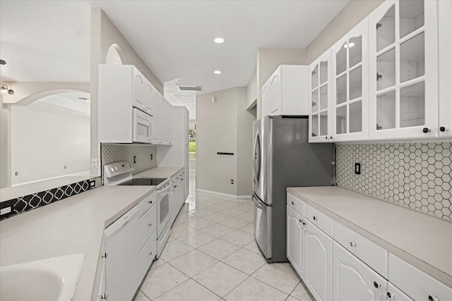 13848 Vista Del Lago Blvd, Clermont, FL 34711 - kitchen featuring white appliances, glass insert cabinets, white cabinetry, tasteful backsplash, and light countertops