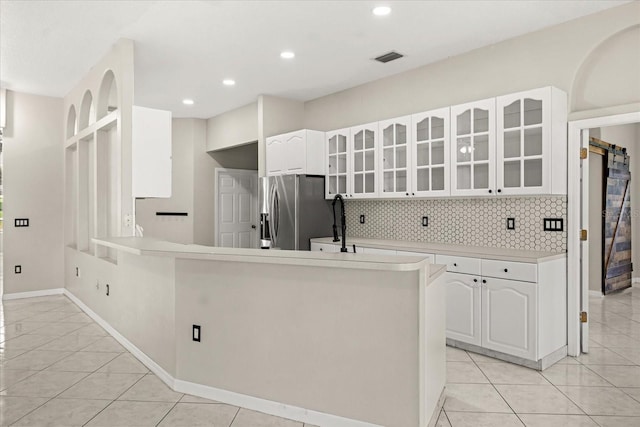 13848 Vista Del Lago Blvd, Clermont, FL 34711 - kitchen with stainless steel fridge, glass insert cabinets, white cabinets, tasteful backsplash, and light tile patterned floors