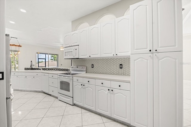 13848 Vista Del Lago Blvd, Clermont, FL 34711 - kitchen featuring white appliances, white cabinets, light countertops, and tasteful backsplash