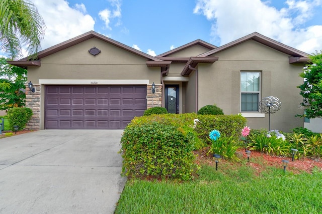 30210 Donnington Loop, Mount Dora, FL 32757 - view of front of house with stucco siding, stone siding, concrete driveway, and an attached garage