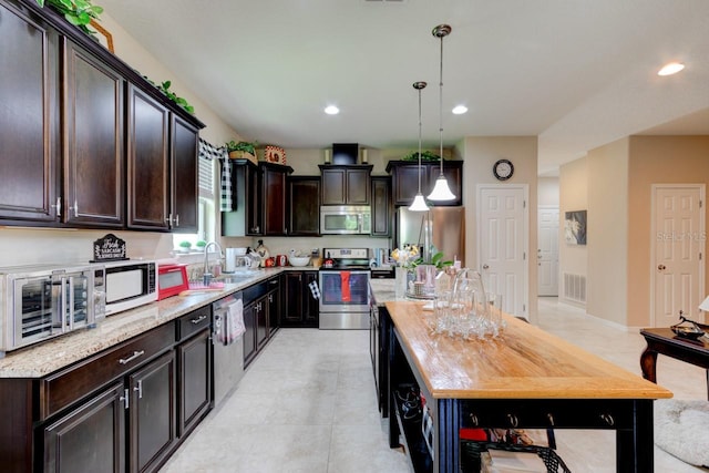 30210 Donnington Loop, Mount Dora, FL 32757 - kitchen featuring stainless steel appliances, dark brown cabinetry, pendant lighting, and recessed lighting