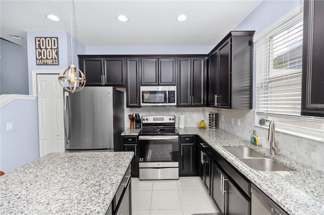 4733 Cliveden Loop, Sanford, FL 32773 - kitchen featuring appliances with stainless steel finishes, tasteful backsplash, light stone counters, light tile patterned floors, and dark cabinets