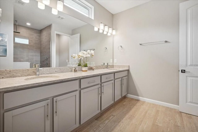 55 Sea Breeze Trl, Palm Coast, FL 32164 - bathroom featuring double vanity, tiled shower, and wood finished floors