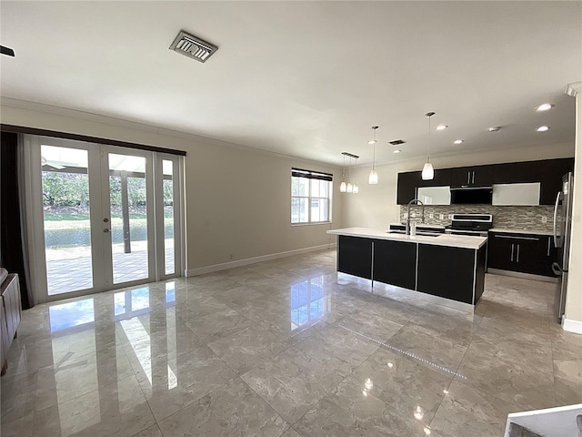 4375 Foxtail Ln, Weston, FL 33331 - kitchen with dark cabinetry, stainless steel appliances, ornamental molding, decorative backsplash, and light countertops