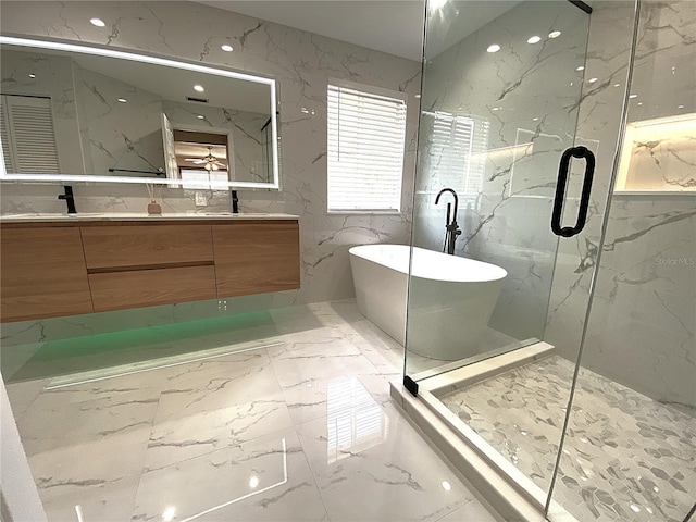 4375 Foxtail Ln, Weston, FL 33331 - bathroom with marble tiled floors, double vanity, stone wall, and a soaking tub