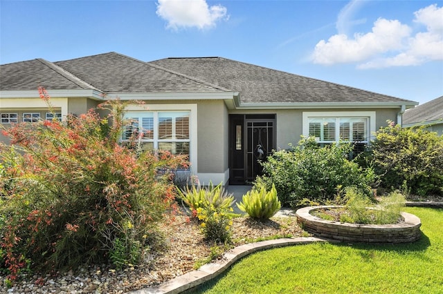 2895 Apache Ct, The Villages, FL 32163 - view of front of home with stucco siding, roof with shingles, an attached garage, and a front lawn