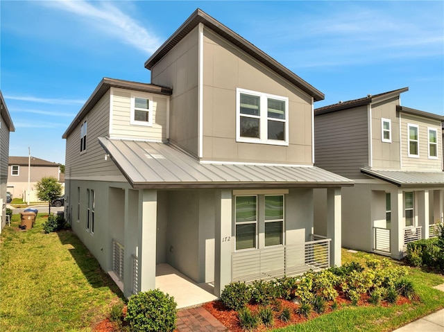 172 S Zuni Rd, Saint Cloud, FL 34771 - modern home with a standing seam roof, stucco siding, a metal roof, a porch, and a front lawn