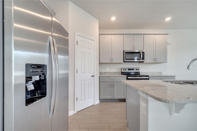 172 S Zuni Rd, Saint Cloud, FL 34771 - kitchen featuring stainless steel appliances, light stone counters, recessed lighting, and light wood-style flooring