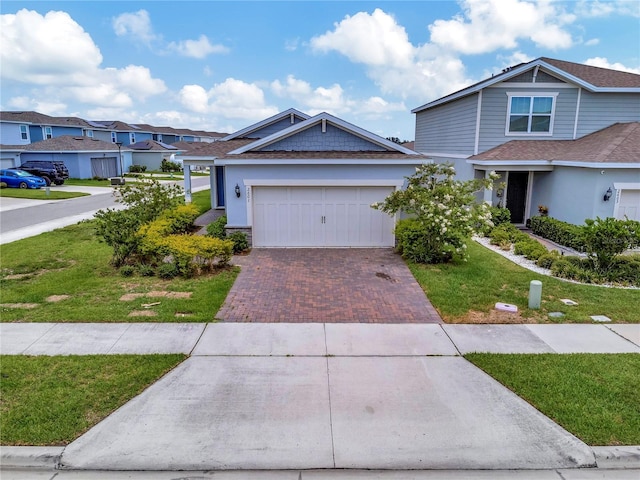 2601 Blowing Breeze Ave, Kissimmee, FL 34744 - view of front of home featuring decorative driveway, a front lawn, an attached garage, and stucco siding
