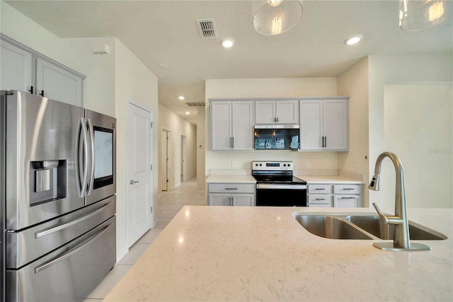 2601 Blowing Breeze Ave, Kissimmee, FL 34744 - kitchen with stainless steel appliances, light tile patterned flooring, light stone countertops, and recessed lighting