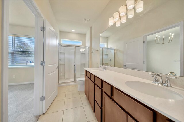 2601 Blowing Breeze Ave, Kissimmee, FL 34744 - bathroom with a stall shower, double vanity, tile patterned floors, and a chandelier