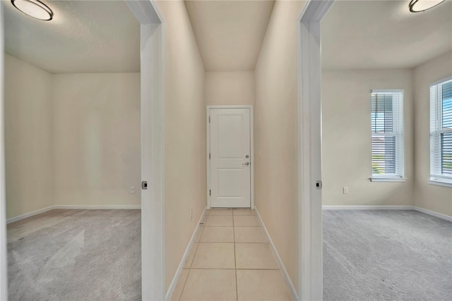 2601 Blowing Breeze Ave, Kissimmee, FL 34744 - hallway with light colored carpet and light tile patterned flooring