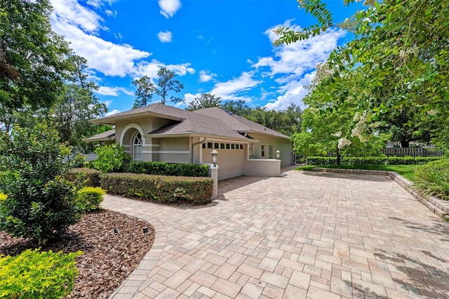 5102 Round Tree Ct, Orlando, FL 32819 - view of property exterior featuring stucco siding, an attached garage, decorative driveway, and roof with shingles