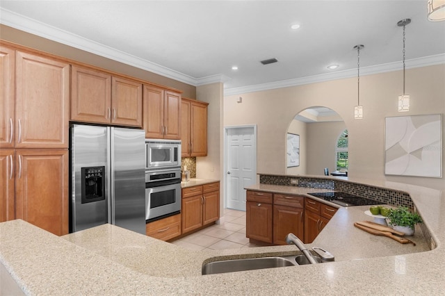 5102 Round Tree Ct, Orlando, FL 32819 - kitchen with stainless steel appliances, arched walkways, crown molding, hanging light fixtures, and light tile patterned floors