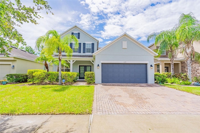 1639 Balsam Willow Trl, Orlando, FL 32825 - traditional-style house with stucco siding, decorative driveway, a front lawn, a garage, and french doors