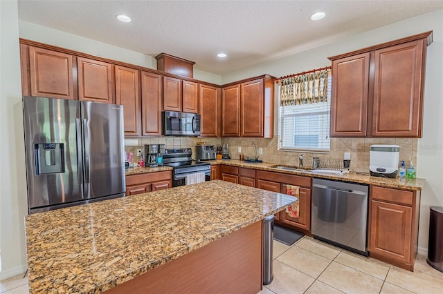 1639 Balsam Willow Trl, Orlando, FL 32825 - kitchen featuring appliances with stainless steel finishes, light stone countertops, decorative backsplash, a center island, and light tile patterned flooring
