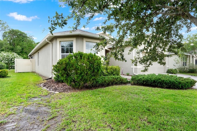 2216 Sequoia Way, Davenport, FL 33896 - view of property exterior featuring stucco siding, a garage, and a yard