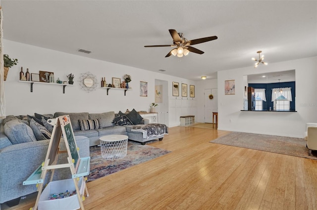 2216 Sequoia Way, Davenport, FL 33896 - living area featuring wood finished floors, a ceiling fan, and a chandelier