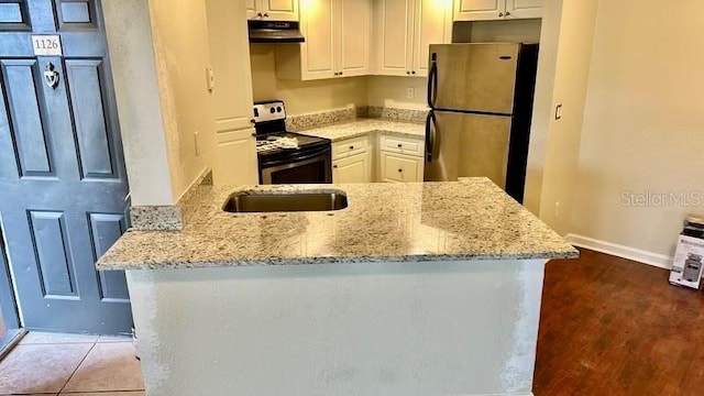 4606 Commander Dr Unit 1126, Orlando, FL 32822 - kitchen with stainless steel appliances, light stone countertops, white cabinetry, and under cabinet range hood