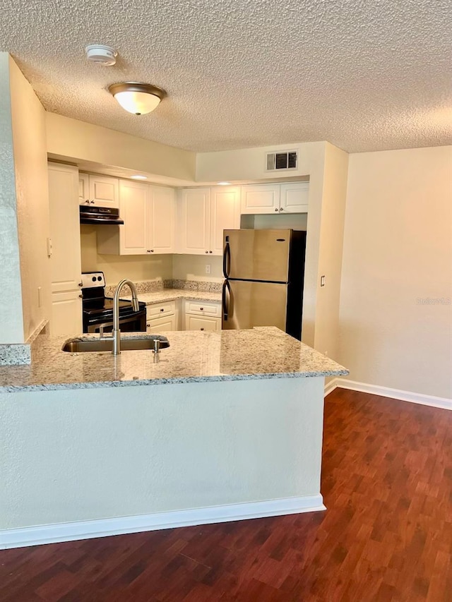 4606 Commander Dr Unit 1126, Orlando, FL 32822 - kitchen with freestanding refrigerator, exhaust hood, light stone countertops, white cabinets, and a peninsula