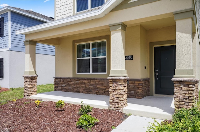 6449 Sprucepine Ln, Saint Cloud, FL 34771 - doorway to property featuring covered porch, stucco siding, and stone siding