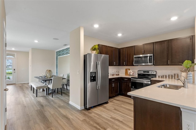 3349 Wynwood Forest Dr, Ocoee, FL 34761 - kitchen featuring stainless steel appliances, dark brown cabinets, light wood-type flooring, light countertops, and recessed lighting