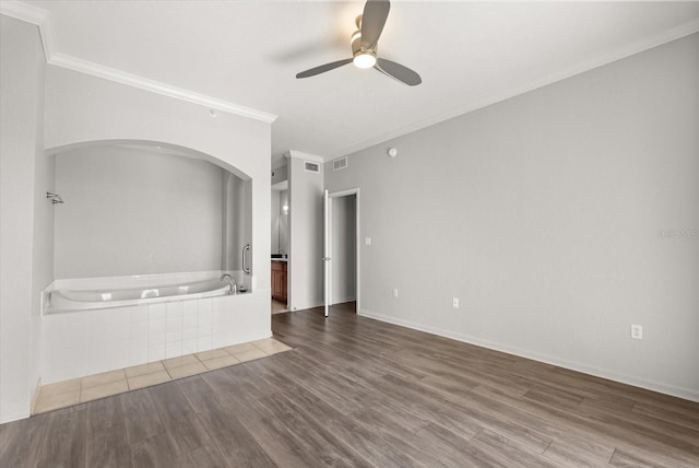 8101 Resort Village Dr Unit 31503, Orlando, FL 32821 - empty room with ornamental molding, ceiling fan, wood finished floors, and arched walkways