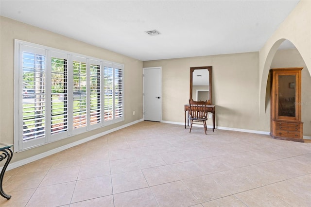 2113 Lochmoor Cir, North Fort Myers, FL 33903 - empty room featuring light tile patterned floors and arched walkways