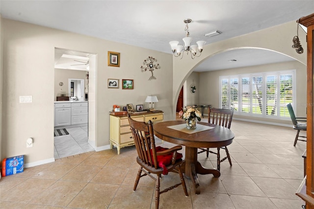 2113 Lochmoor Cir, North Fort Myers, FL 33903 - dining space with arched walkways, light tile patterned floors, a chandelier, and ceiling fan