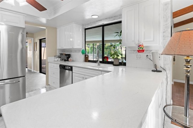2113 Lochmoor Cir, North Fort Myers, FL 33903 - kitchen with appliances with stainless steel finishes, white cabinets, decorative backsplash, and light countertops