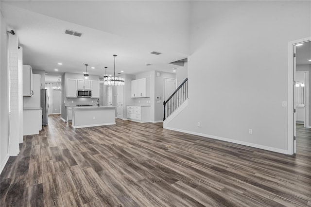 840 Livestock Loop, Saint Cloud, FL 34771 - unfurnished living room featuring recessed lighting, dark wood-style flooring, stairway, and a chandelier