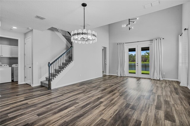 840 Livestock Loop, Saint Cloud, FL 34771 - unfurnished living room featuring washer and clothes dryer, a chandelier, dark wood-style floors, and a high ceiling