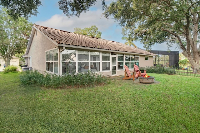 1073 Sadie Ln, Winter Garden, FL 34787 - rear view of house featuring an outdoor fire pit, stucco siding, a tile roof, and a sunroom