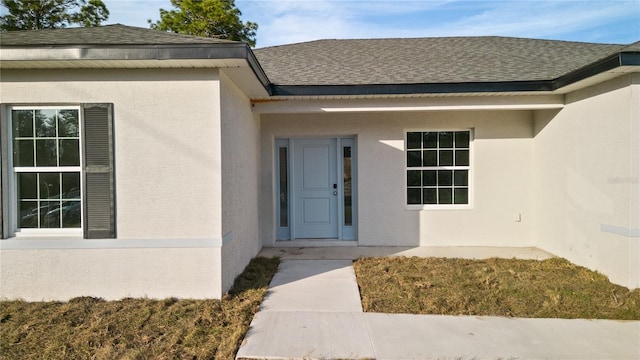 709 Marion Oaks Mnr, Ocala, FL 34473 - doorway to property featuring stucco siding and roof with shingles
