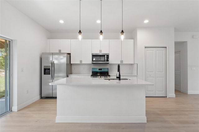 709 Marion Oaks Mnr, Ocala, FL 34473 - kitchen with appliances with stainless steel finishes, an island with sink, white cabinets, light wood-style floors, and recessed lighting