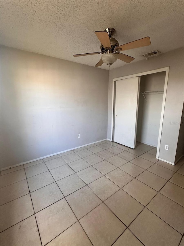 5265 Broken Arrow Dr, Kissimmee, FL 34746 - unfurnished bedroom featuring a textured ceiling, light tile patterned flooring, a closet, and a ceiling fan