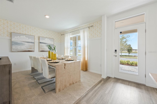 3413 Wynwood Forest Dr, Ocoee, FL 34761 - dining space with wallpapered walls, light wood-style floors, and a water view