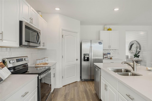 3413 Wynwood Forest Dr, Ocoee, FL 34761 - kitchen featuring stainless steel appliances, light countertops, light wood-type flooring, white cabinetry, and recessed lighting