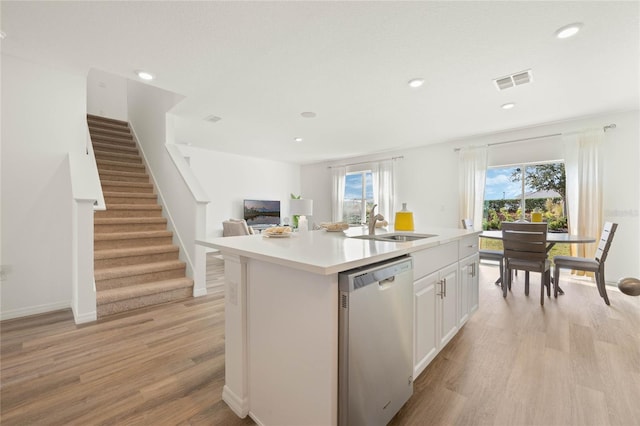 3413 Wynwood Forest Dr, Ocoee, FL 34761 - kitchen with stainless steel dishwasher, light wood finished floors, white cabinetry, light countertops, and an island with sink