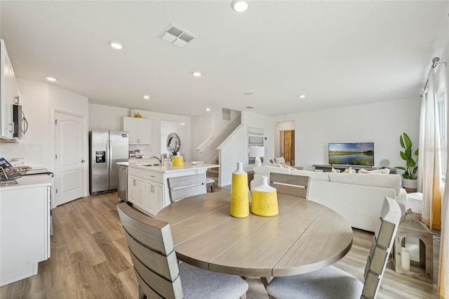 3413 Wynwood Forest Dr, Ocoee, FL 34761 - dining space with light wood-style floors, recessed lighting, and stairway