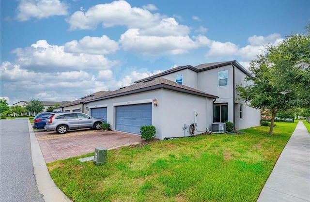 14007 Picard Aly, Winter Garden, FL 34787 - view of side of home featuring decorative driveway, a garage, a yard, and stucco siding