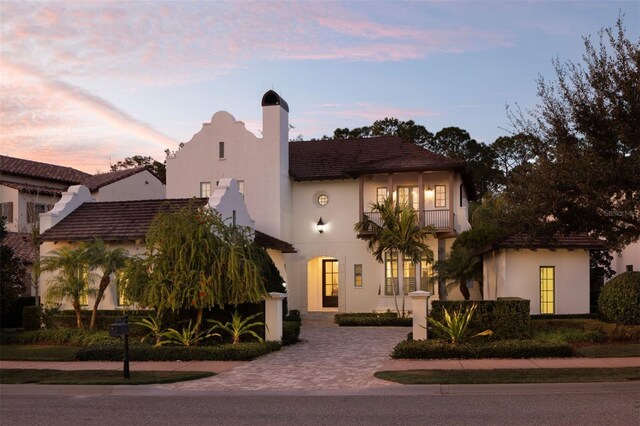 10143 Mattraw Pl, Golden Oak, FL 32836 - view of front of home featuring a balcony, a chimney, and stucco siding