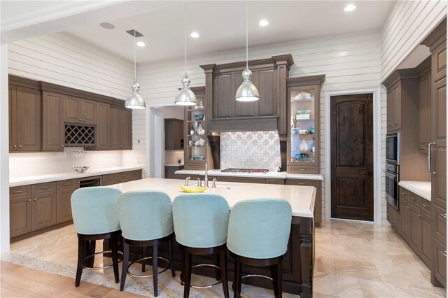 10143 Mattraw Pl, Golden Oak, FL 32836 - kitchen with light countertops, stainless steel appliances, decorative backsplash, a kitchen island with sink, and recessed lighting