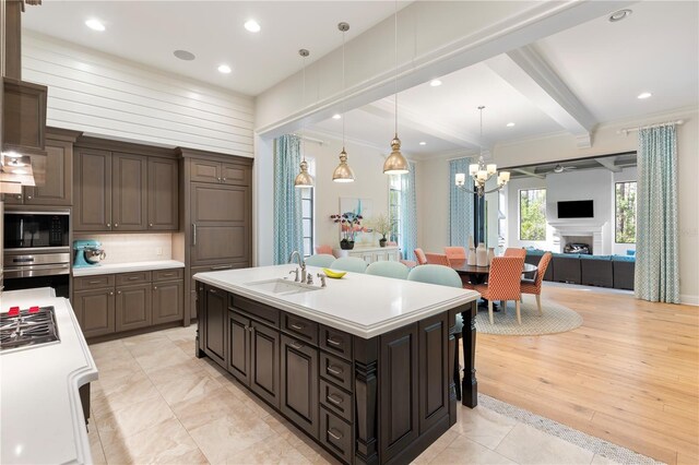 10143 Mattraw Pl, Golden Oak, FL 32836 - kitchen featuring open floor plan, appliances with stainless steel finishes, a chandelier, light countertops, and ornamental molding